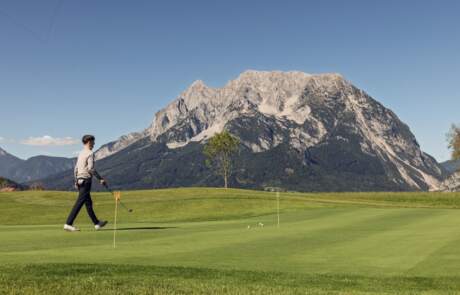 Bild: Golfspieler am GCC Schloss Pichlarn mit Grimming im Hintergrund